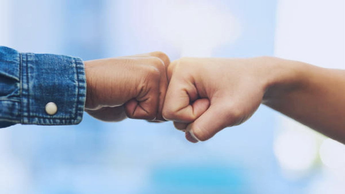 Closeup shot of two people fist bumping each other